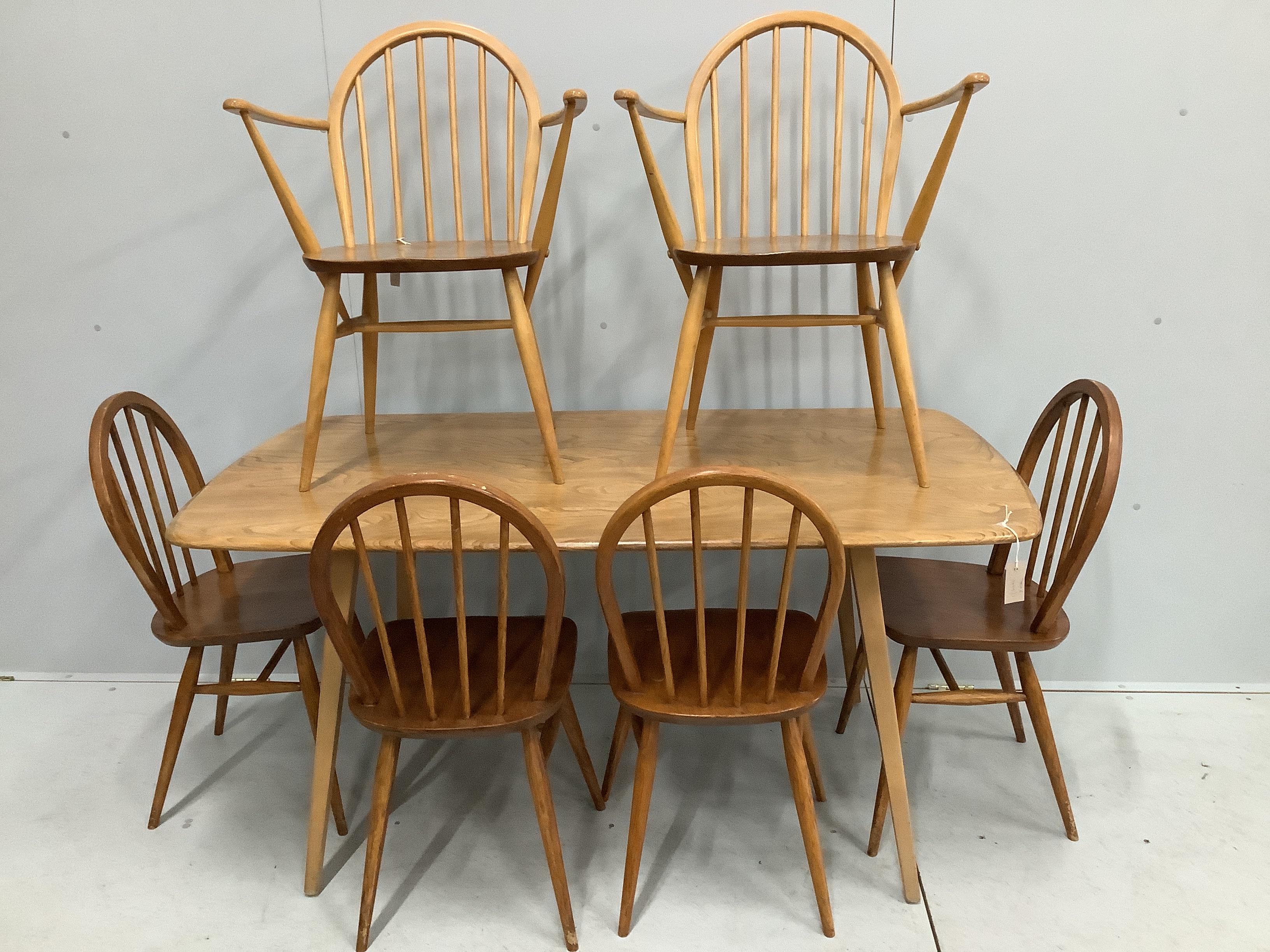 An Ercol rectangular elm and beech dining table, width 152cm, depth 84cm, height 71cm together with a pair of Ercol elm and beech elbow chairs and four Ercol standard dining chairs